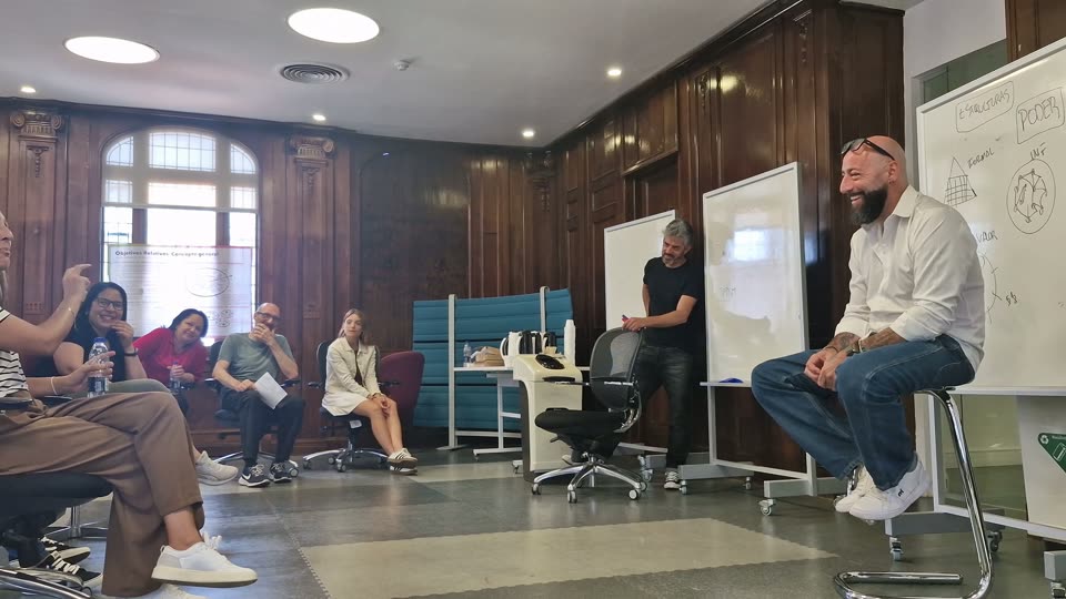 Un grupo sentado en ronda conversa con un consultor de Adaptant durante una sesión de trabajo